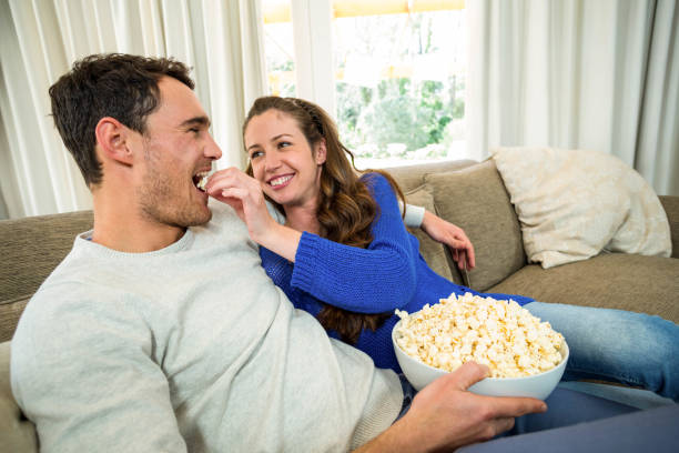 istock Young couple eating popcorn on sofa 851720846