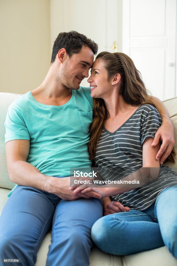 Jovem casal carinhos no sofá - Foto de stock de 20 Anos royalty-free Jovem casal carinhos no sofá - Foto de stock de 20 Anos royalty-free