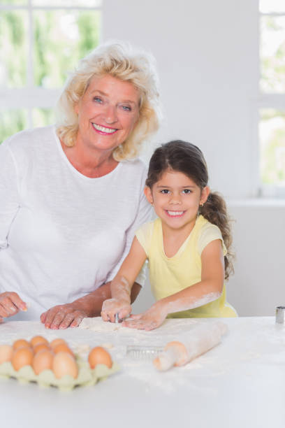 istock Granddaughter and grandmother preparing biscuits together 851722094