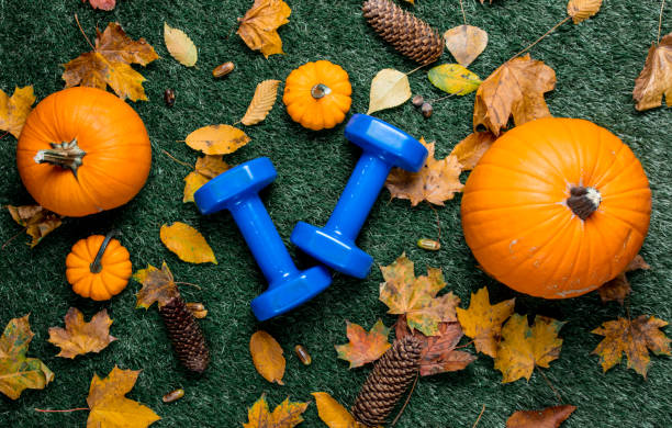 Blue dumbbells and autumn leaves with pumpkin stock photo