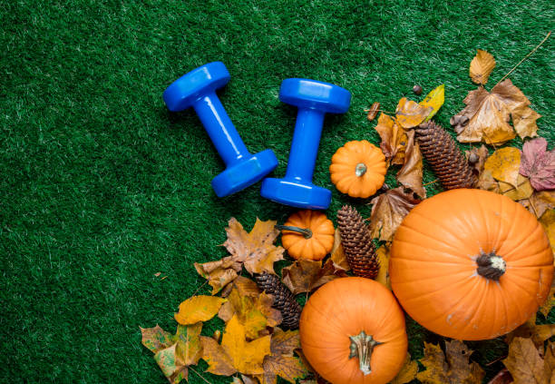 istock Blue dumbbells and autumn leaves with pumpkin 851735404