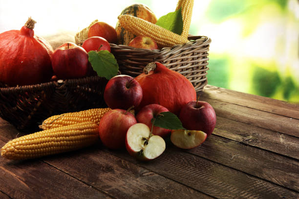 Thanksgiving - pumpkin, apples, and maize on wooden background