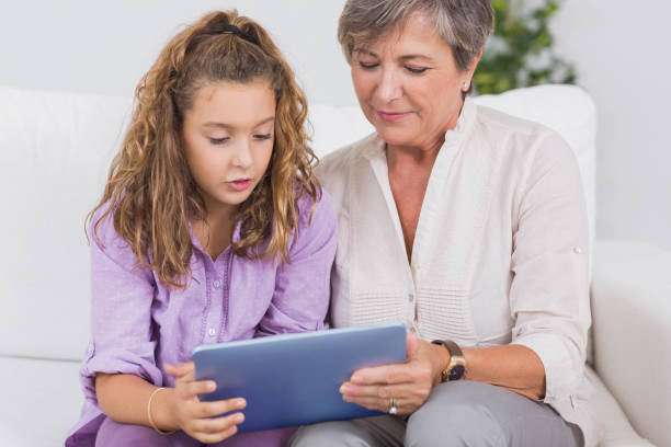 istock Child and her grandmother holding tablet pc 851762982
