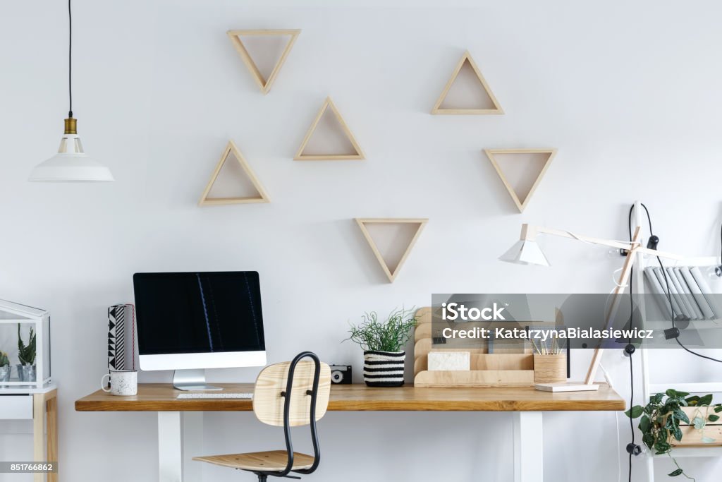 Wooden geometric frames on wall Wooden geometric frames on white wall in freelancer's room with plant in striped material pot Elegance Stock Photo
