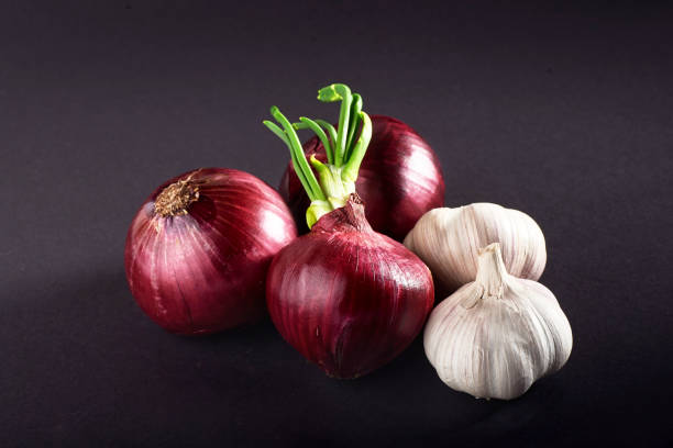 istock Blue purple onion and garlic isolated white on a black background 851767296