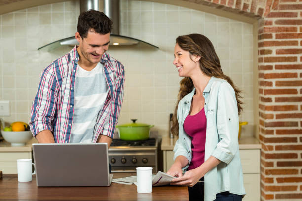 istock Man using laptop and woman reading newspaper 851767354