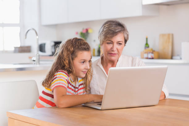 istock Child and granny looking at laptop 851770492