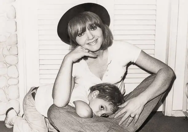 Vintage black and white photo from the seventies of a mother and child playing at home.