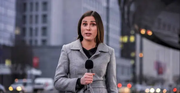 Portrait of newsreader talking on microphone.