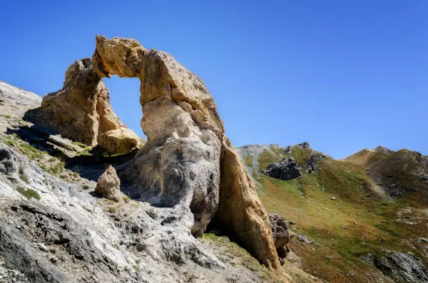 The Arc de Tortisse, famous natural limestone arch in the national park of Mercantour near the lake of Vens (France)