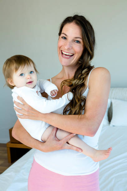 istock smiling brunette woman holding a cute baby 851785498