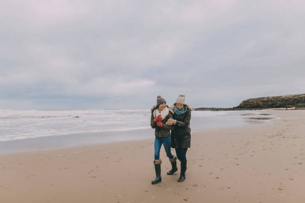 istock Young Women Walking Along A Winter Beach 851789446