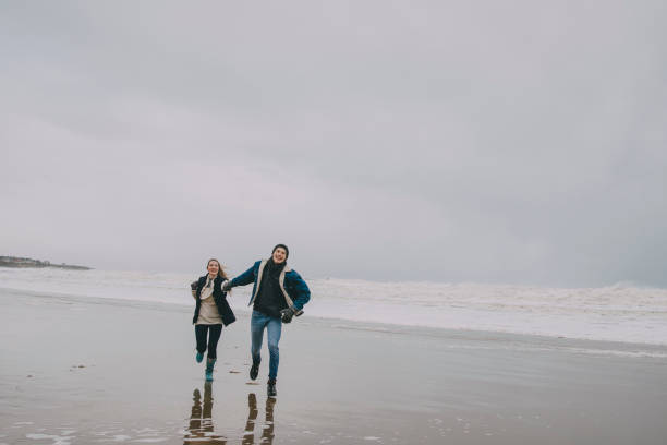 istock Young Couple Walking Along A Winter Beach 851789452