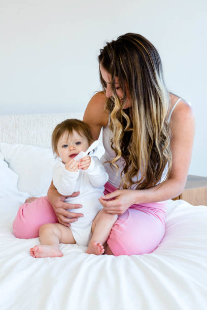 istock cute baby playing with a comb in a womans lap 851789836