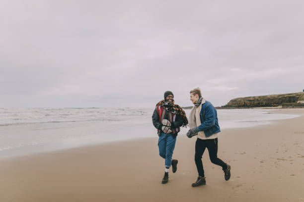 istock Young Adults Walking Along A Winter Beach 851790108