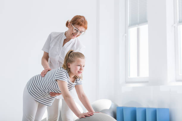 istock Physiotherapist improves position of girl 851793312