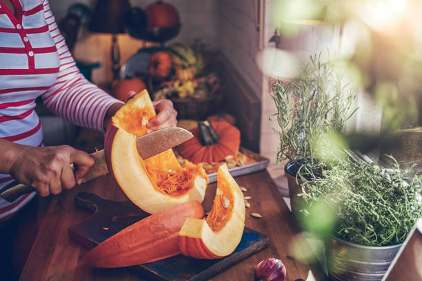 cutting fresh pumpkins for roasting in the oven - butternut squash roasted squash cooked imagens e fotografias de stock