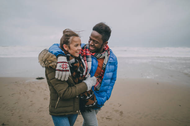 Young Couple Walk Along Winter Beach