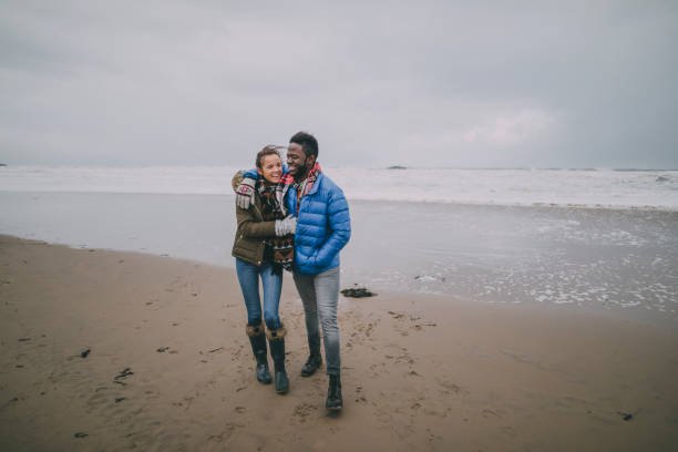 istock Young Couple Take Romantic Walk On A Winter Beach 851795040