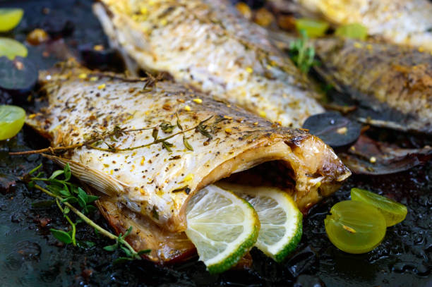 istock Baked carp with grapes, lime and herbs on black. 851800466