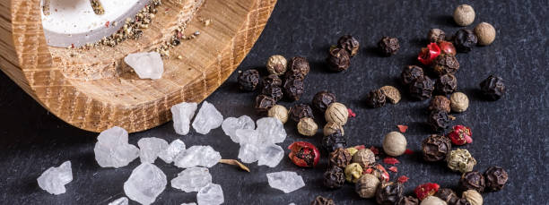istock Pepper Mill, Sea Salt and Pepper Grains on Dark Stone Surface Close Up 851801088