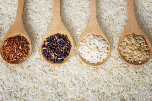 istock Top view different rice on wooden scoop with jasmine rice background, Various rice organic on wooden spoon collection 851802192