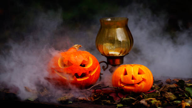 istock Halloween pumpkins on wood table in a creepy forest. 851802718