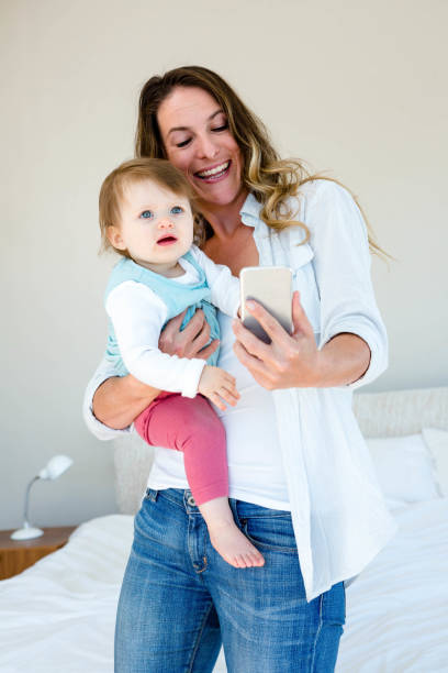 istock smiling woman taking a selfie with a baby 851805398
