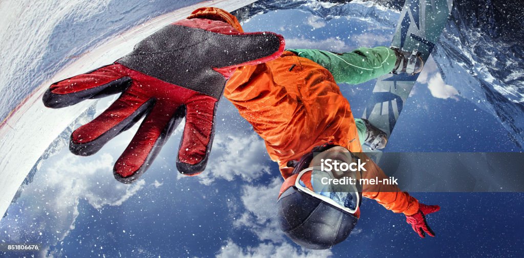 Sport background. Winter sport. Snowboarder jumping through air with deep blue sky in background. Top view Sport in winter. Young man jumps with the snowboard in the mountains. Snowboarding Stock Photo