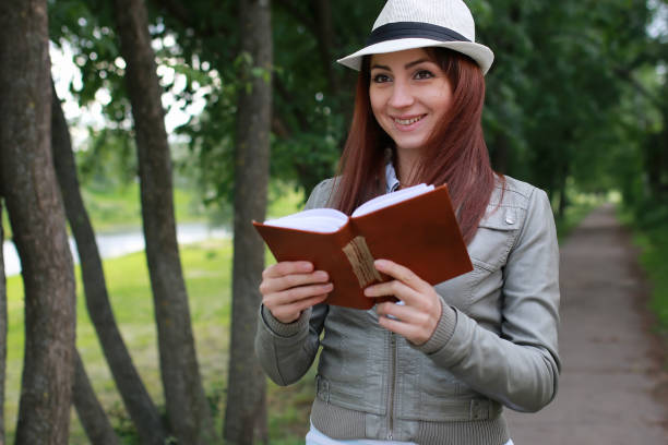 istock girl with book in park 851809472