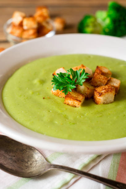 istock Broccoli cream soup with croutons in plate on rustic wooden table 851824926