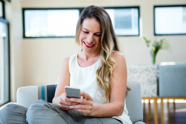 istock smiling woman looking at her mobile phone 851825226