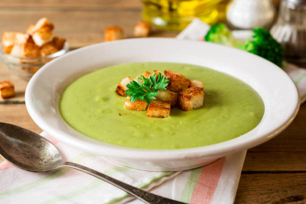 istock Broccoli cream soup with croutons in plate on rustic wooden table 851826236