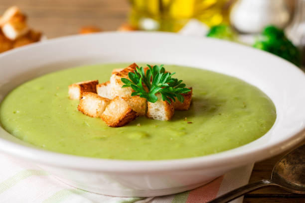 istock Broccoli cream soup with croutons in plate on rustic wooden table 851826362