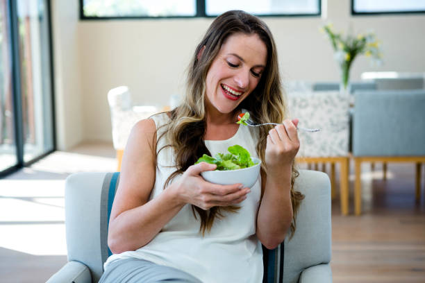 istock smiling woman eating a salad 851829750