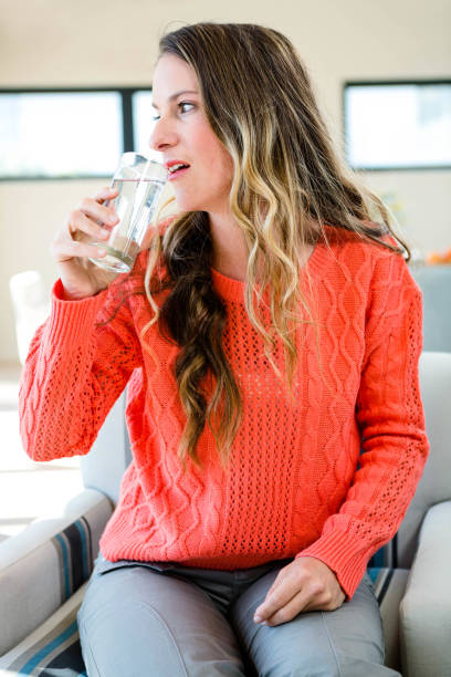 istock distracted woman drinking a glass of water 851829848