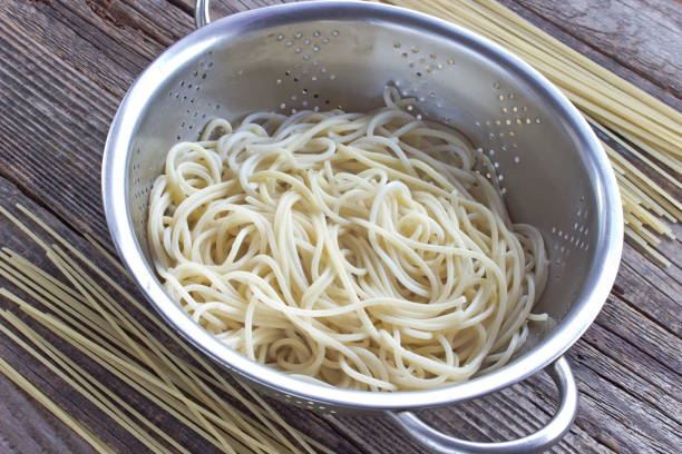 istock Cooked spaghetti pasta in strainer on wooden table 851832758