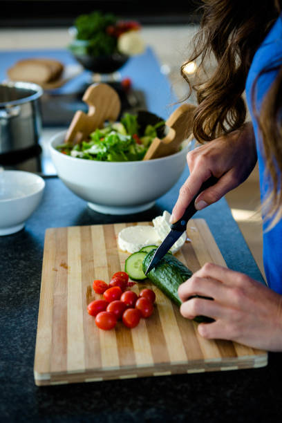 istock woman slicing vegetables for dinner 851836556