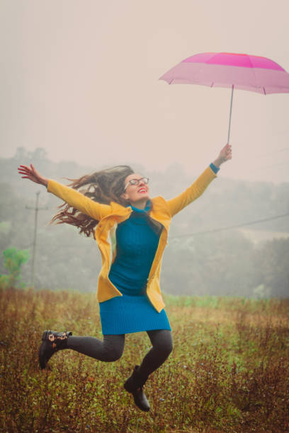 istock Cheerful woman jumping with umbrella 851837734