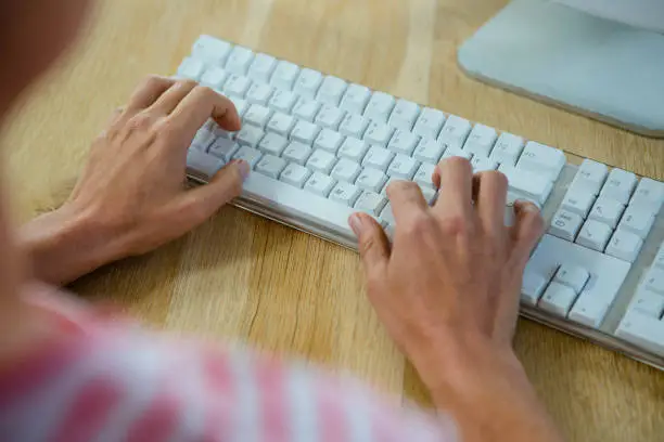 female hands typing on a keyboard, on a desk