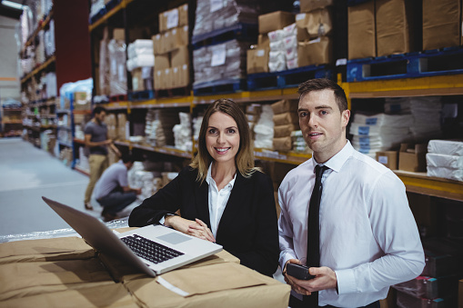 Warehouse managers using laptop in warehouse