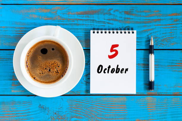 istock October 5th. Day 5 of october month, calendar on workbook with coffee cup at student workplace background. Autumn time 851851466