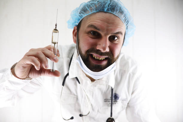 istock Crazy bearded doctor in a white coat and old syringe 851859018
