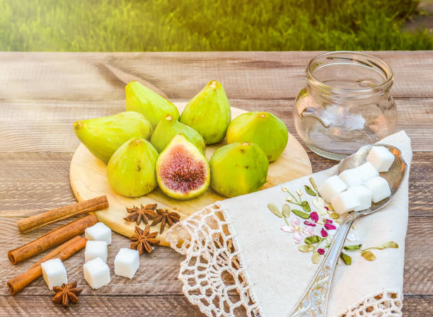 still life with figs, jam cooking process. fresh green figs on wooden background, surrounded by spices, embroidered napkin, vintage spoon. - 6720 imagens e fotografias de stock