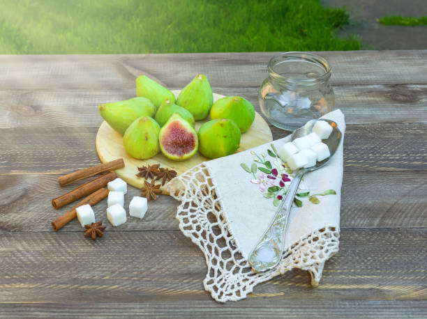 still life with figs, jam cooking process. fresh green figs on wooden background, surrounded by spices, embroidered napkin, vintage spoon. - 6720 imagens e fotografias de stock