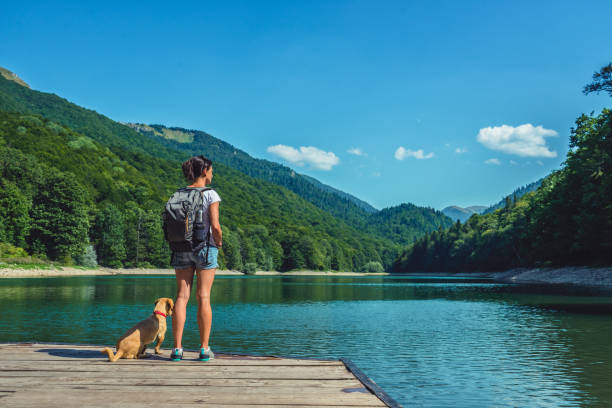 Woman with a dog standing on a pier