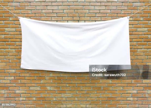 Cloth Banner Hanging On Brick Wall Stock Photo - Download Image Now - Banner - Sign, Hanging, Textile