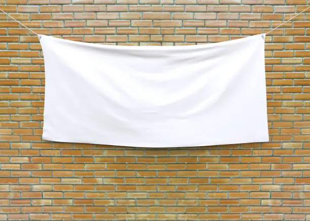 Cloth banner hanging on brick wall. 3D illustration