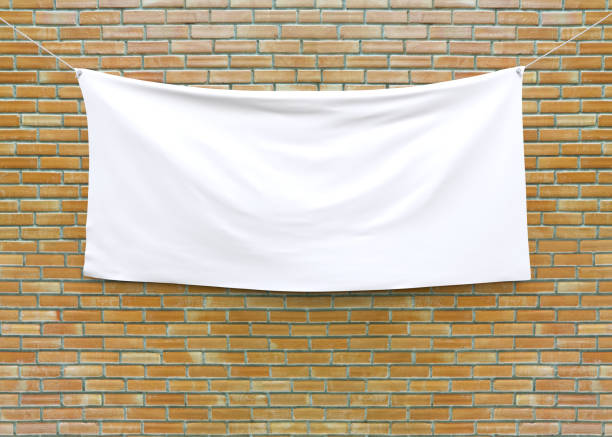 cloth banner hanging on brick wall. - hanging imagens e fotografias de stock