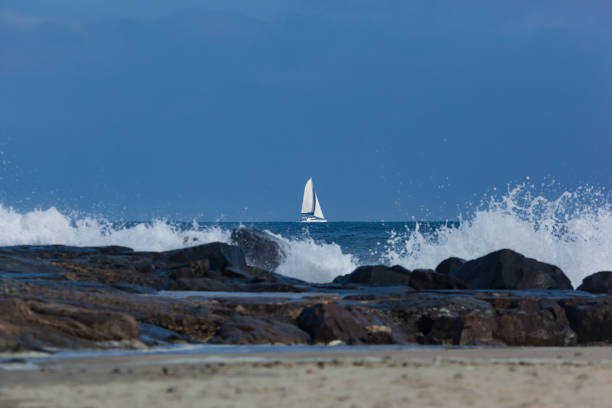 A catamaran sailboat sails past the jetty in Deal, New Jersey. Tropical Storm Jose made for some rough water.